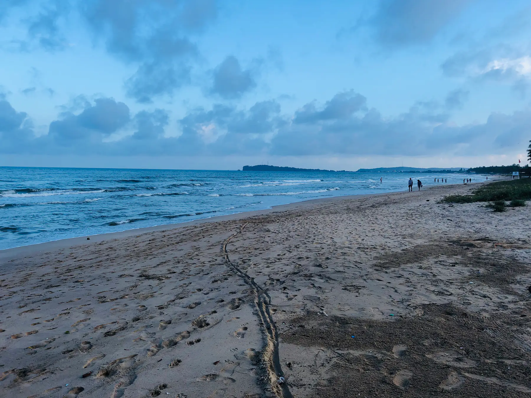 Sandy beach and sea at Nilaveli under a cloudy sky.