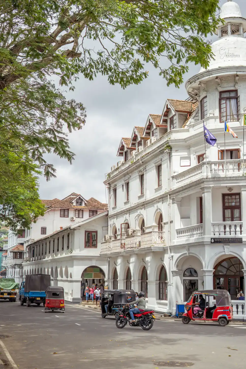Colonial buildings and tuk-tuks on a street in Kandy.