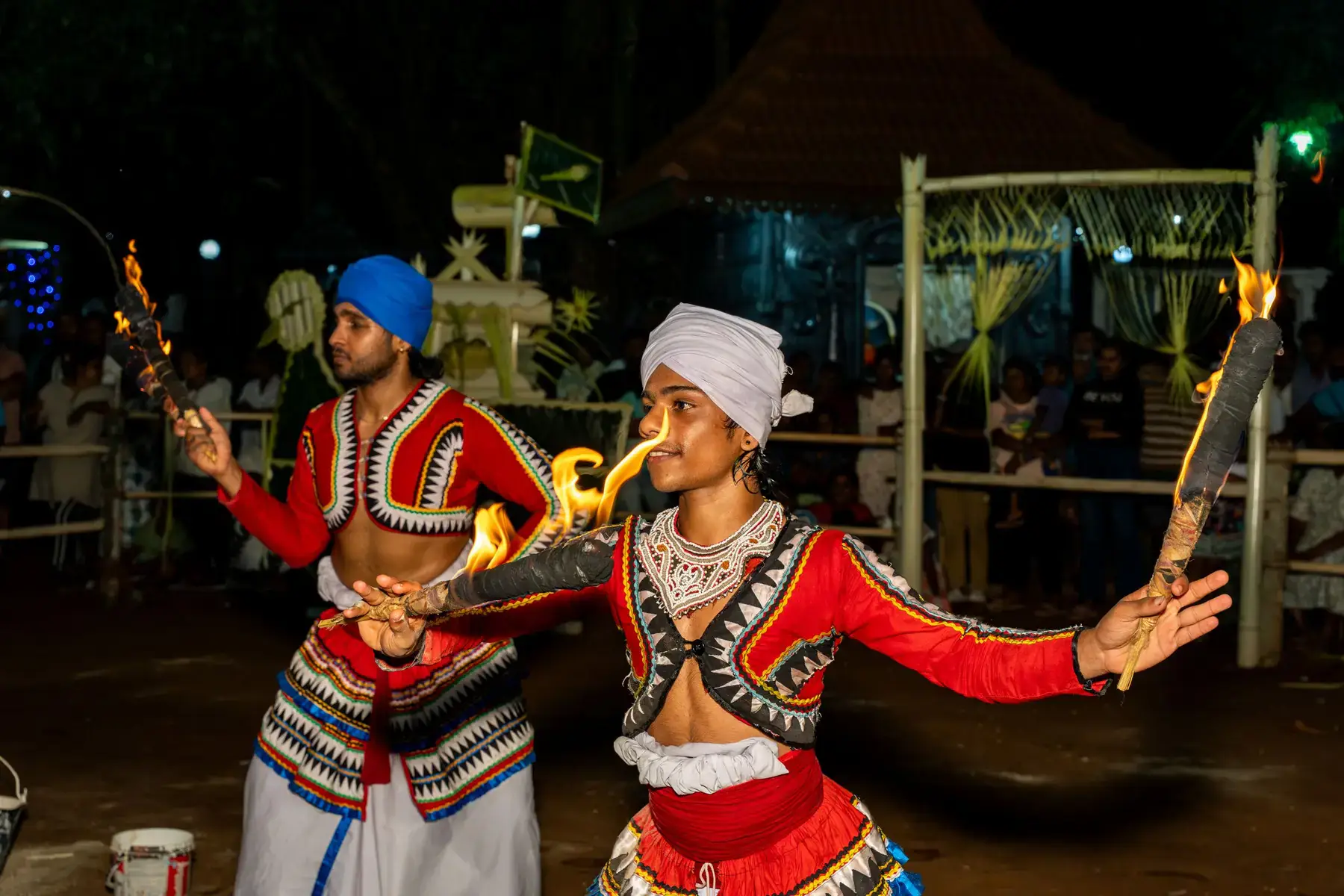 A traditional fire-torch dance at a night festival.