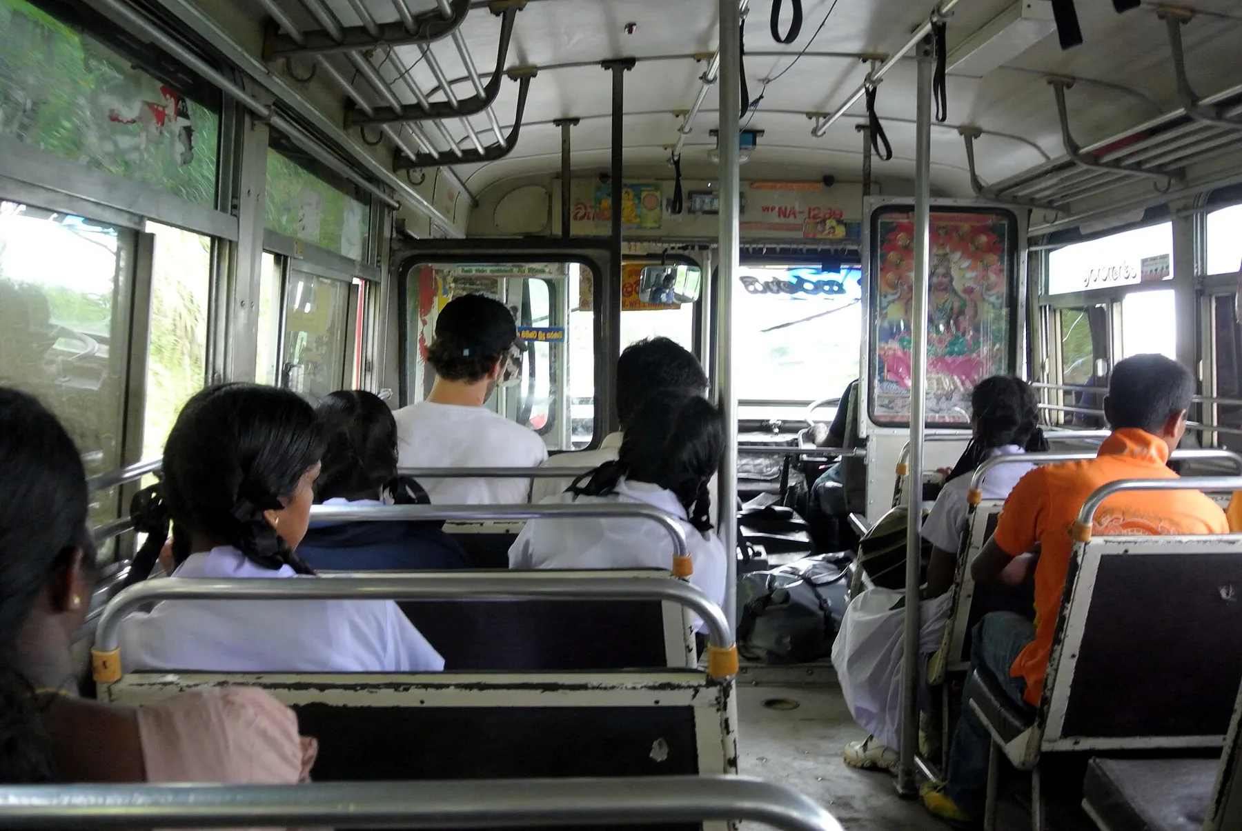 Passengers seated inside a Sri Lankan bus in Badulla district, seen from the aisle toward the front.